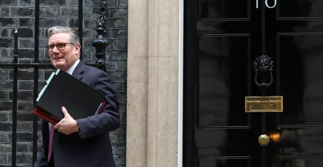 Keir Starmer leaving Downing Street carrying a selection of folders under his arm.