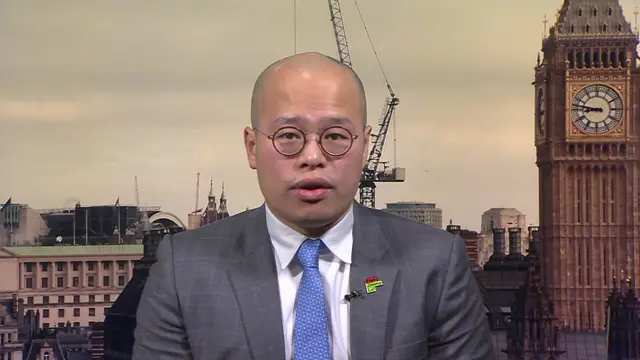 Sebastien Lai pictured with a grey suit with Westminster in the background.
