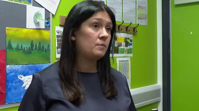 Culture secretary Lisa Nandy speaking to a reporter against a green wall at a school