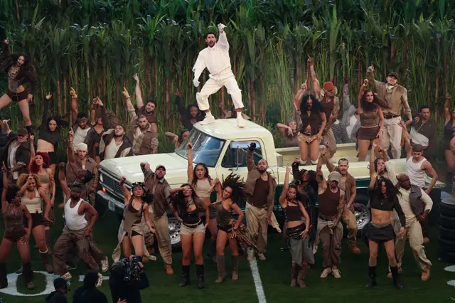 Bad Bunny performs on a car