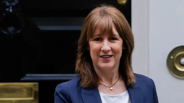 Rachel Reeves in dark blue blazer and white shirt photographed outside the black door of Number 10, Downing Street