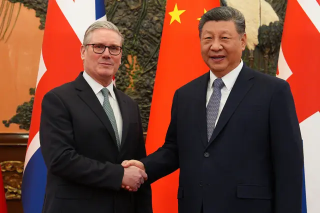 UK Prime Minister Keir Starmer (L) shakes hands with Chinese leader Xi Jinping