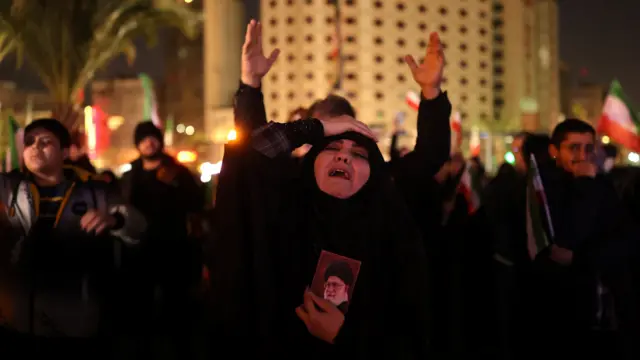 A woman holds on to a picture of Iran's Supreme Leader Ayatollah Ali Khamenei at the Vali-Asr Square