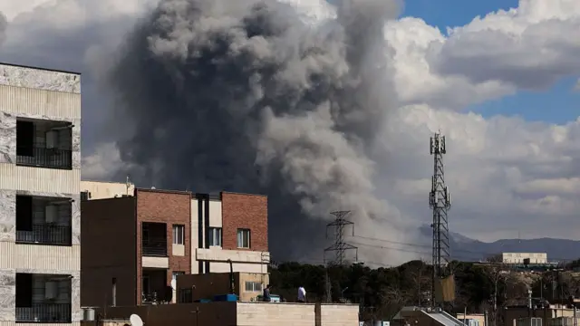 A plume of smoke rises following reported explosions in Tehran