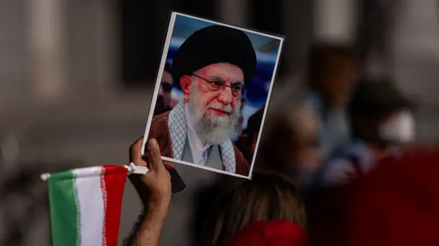 A demonstrator holding portrait of Iran's Supreme Leader Ayatollah Ali Khamenei