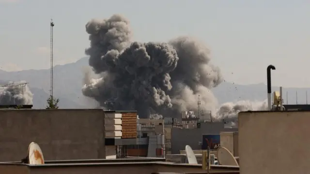 An explosion with large plumes of smoke over buildings in Tehran.