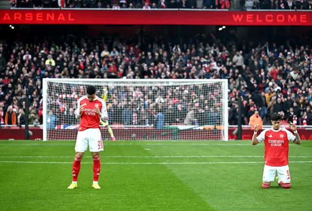 William Saliba and Piero Hincapie of Arsenal pray on the pitch