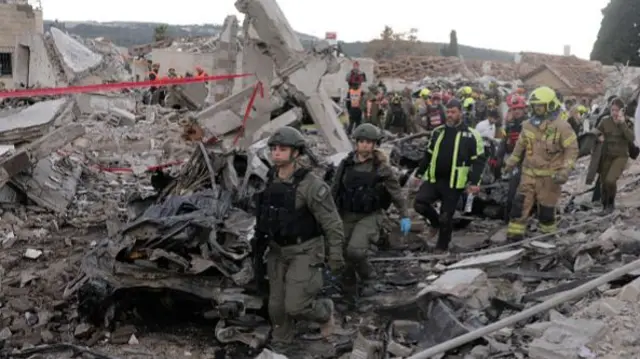Rescue workers and military personnel at the site of an Iranian missile strike in Beit Shemesh, Israel