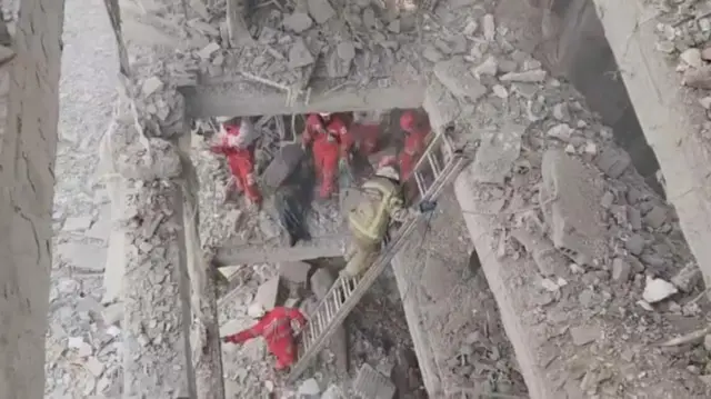 Rescuers work in the rubble of residential buildings after air strikes in Tehran - this is a screengrab from a video released by the Iranian Red Crescent Society