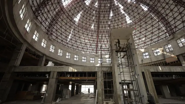 A dome inside the unfinished Nepali parliament building with a construction worker on scaffolding