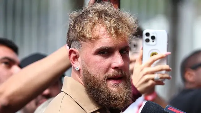 Jake Paul asks a question on a microphone