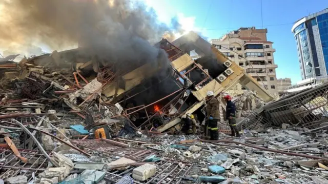 Members of the Lebanese Civil Defence inspect a damaged building after an Israeli strike on Beirut's southern suburbs on Monday