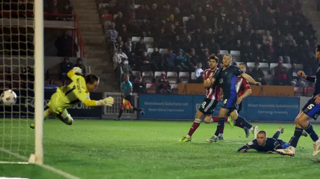 Tom Hamer heads in Lincoln's goal at Exeter