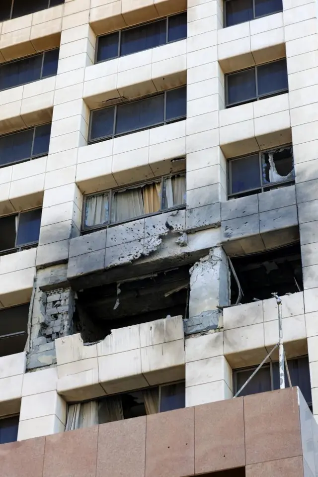 Damage to the outside of a beige coloured building cause by an Israrli strok