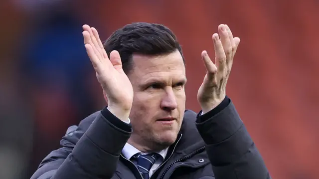 Wigan Athletic boss Gary Caldwell applauding the fans at the final whistle.