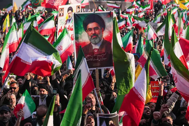 A demonstrator holds a picture of Iran's new Supreme Leader Ayatollah Mojtaba Khamenei at Enghelab Square in central Tehran on March 9, 2026. Large crowd holds Iranian flags