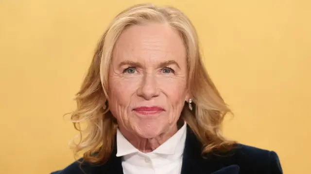 Amy Madigan in a black jacket and white shirt, she blonde hair