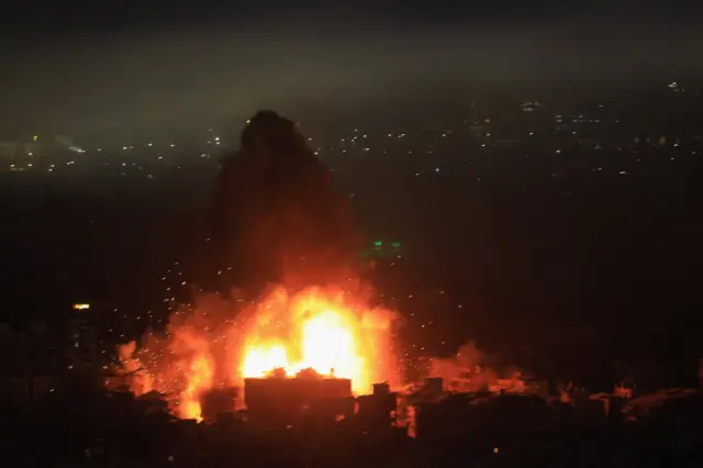 A large explosion in a city in the dark