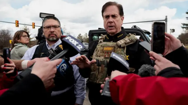 Sheriff Bouchard speaks to press who are holding microphones up to him