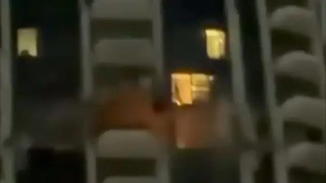 Building with flames protruding from hole