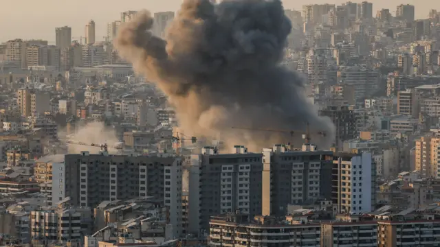 smoke rises above apartments in Beirut after a strike on the city