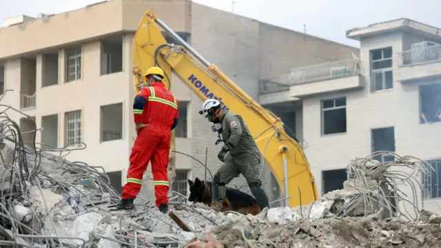 Iranian rescue workers work among the rubble of damaged residential buildings in central Tehran