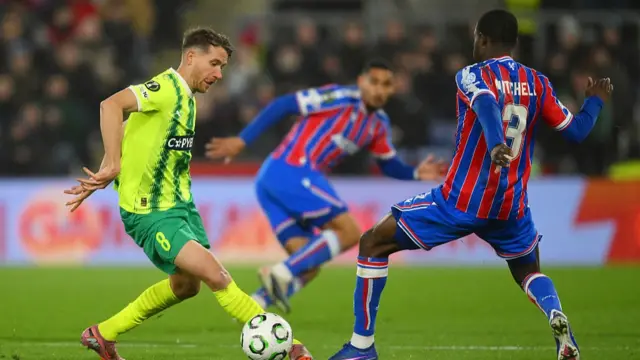: Marcus Rohden of AEK Larnaca is challenged by Tyrick Mitchell of Crystal Palace