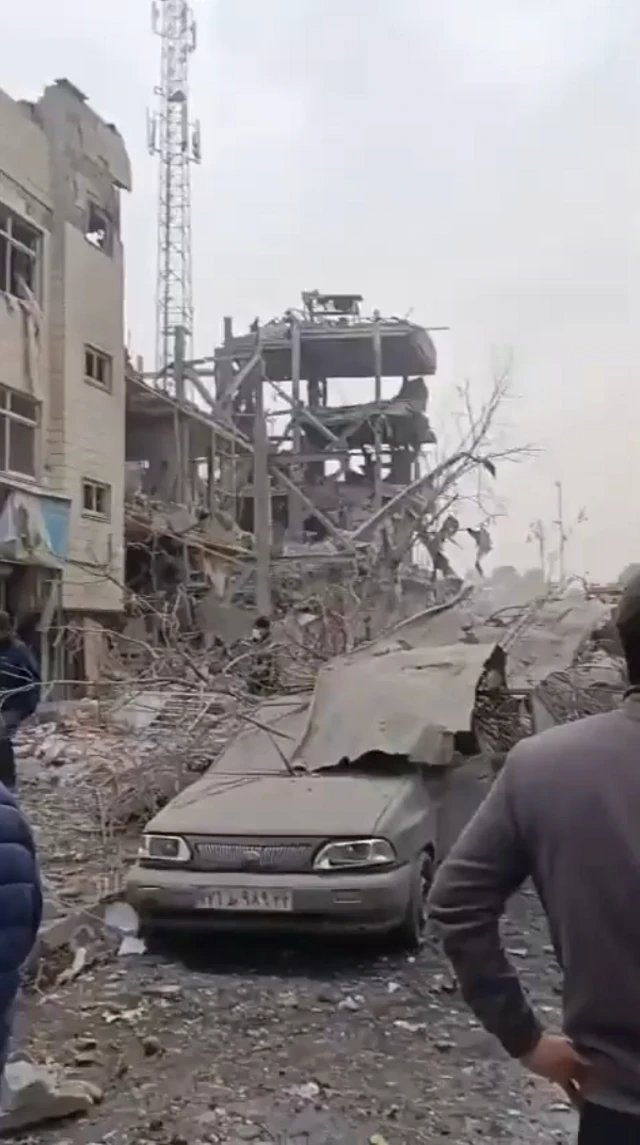 A screengrab from a video on social media, taken on 10 March, which the BBC has verified. It shows a destroyed Basij building near Mehrabad airport in Iran. It shows a car that has been mashed up with rubble and a building in the background that has been gutted by a strike