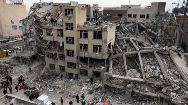 Iranians collect belongings from the rubble of a damaged residential building in Tehran