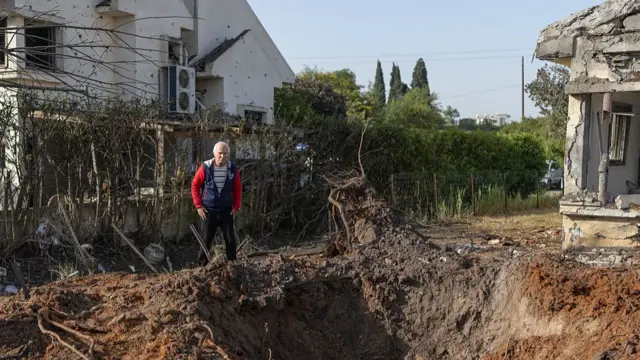 A man looks at the damage after a house was hit by a rocketin central Israel