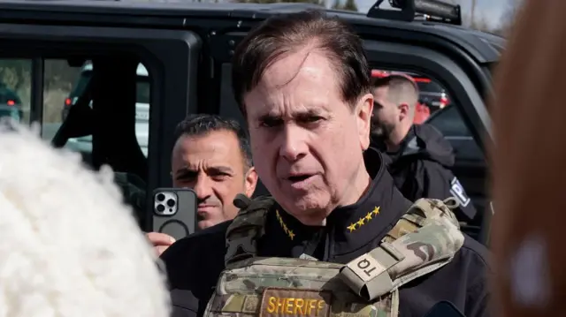 close-up of sheriff's face, speaking to reporters