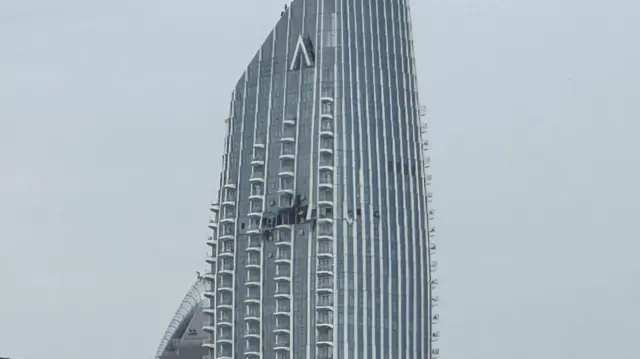 High-rise building with hole in the side of it near the top