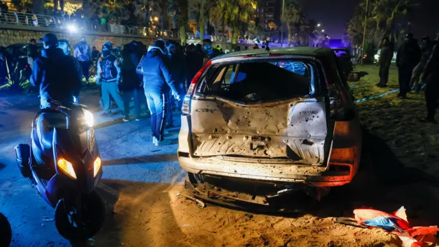 A damaged car is pictured on a road in Ramlet al-Baida in Beirut
