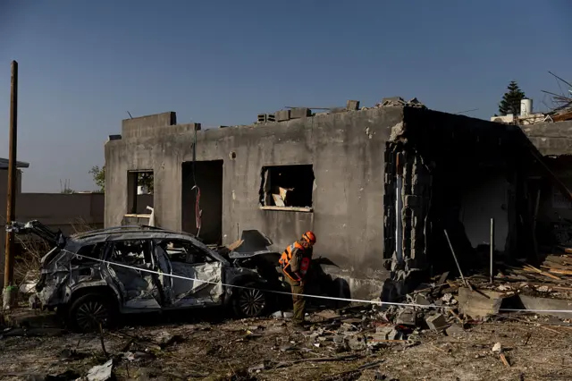 An emergency worker inspecting a house that was destroyed in Zarzir near Nazareth