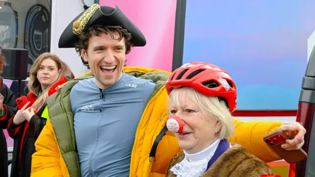 Greg grins in a pirate hat and the mayor is next to him wearing a red nose reading 'mayor of Weymouth'