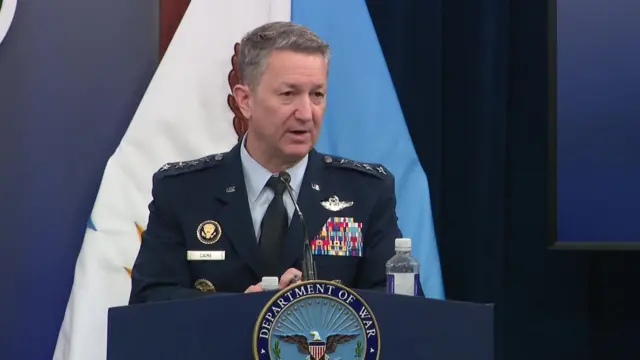 Chủ tịch Hội đồng Tham mưu trưởng Liên quân Dan Caine trong quân phục đang cập nhật thông tin cho báo chí bên trong một căn phòng tại Lầu Năm Góc.