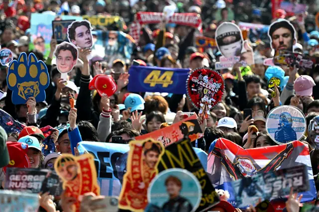 Fans hold up signs in China