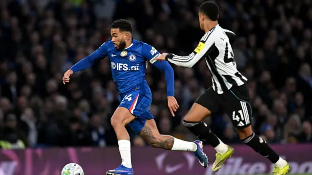 Reece James runs with the ball while under pressure from Jacob Ramsey