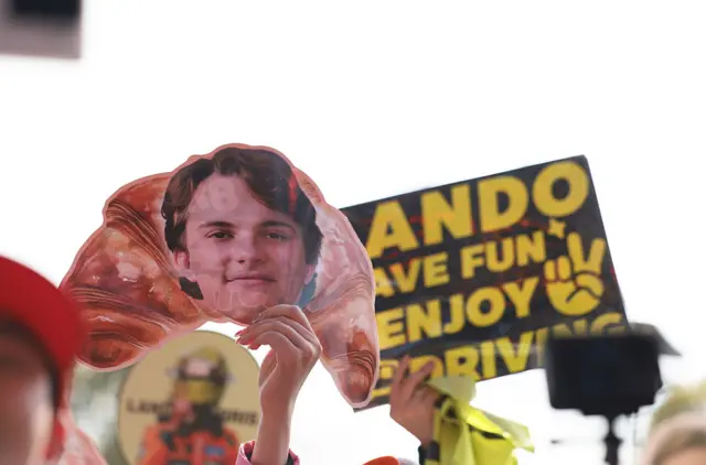 Fans hold up signs