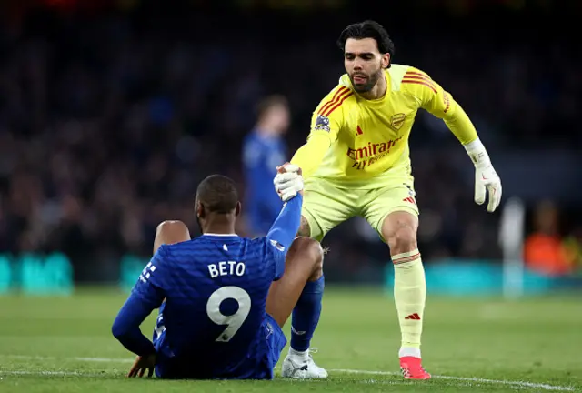 David Raya of Arsenal helps Beto of Everton get back to his feet
