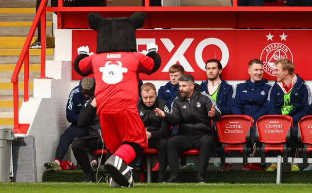 Aberdeen mascot runs up to Aberdeen bench