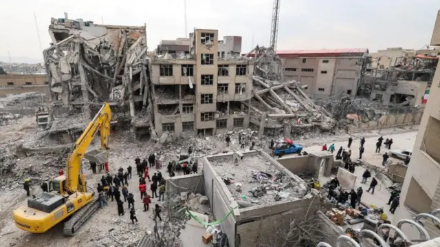 People gather at the site of an air strike, amid the U.S.-Israeli conflict with Iran, in Tehran