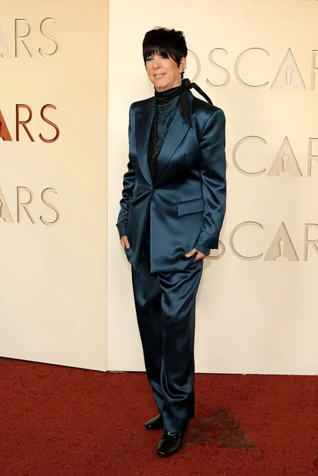 Warren wears a dark-blue satin suit