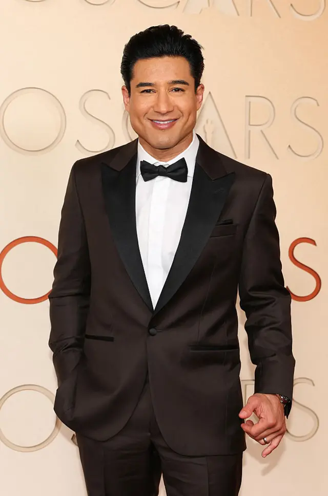 Lopez poses in black tuxedo