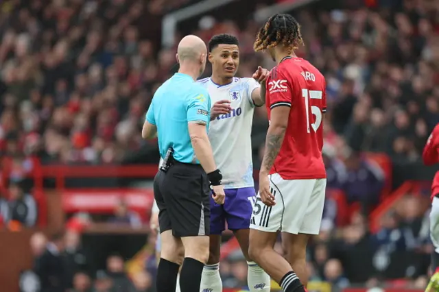 Referee Antony Taylor speaks to Ollie Watkins of Aston Villa and Lenny Yoro