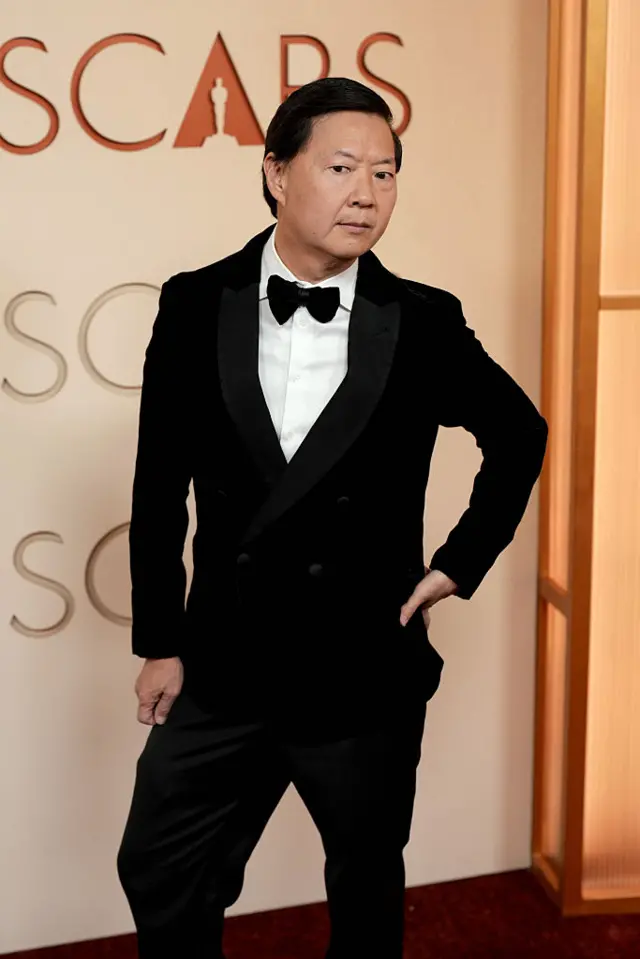 Ken Jeong poses for a photo wearing a black tuxedo