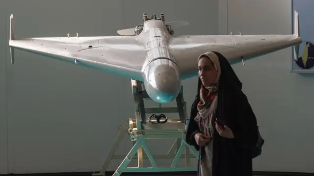 A veiled Iranian schoolgirl stands in front of Iran's Shahed-136 unmanned aerial vehicle while visiting of Iran's Islamic Revolutionary Guard Corps (IRGC) National Aerospace Park in western Tehran, October 11, 2023