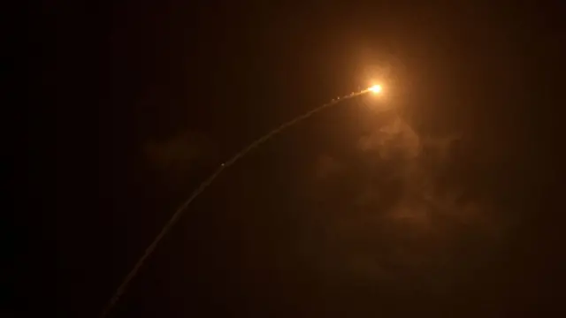 Streaks of light illuminate the night sky during a missile interception.