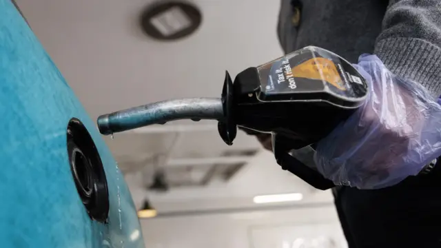 Someone fills up a car with a petrol pump