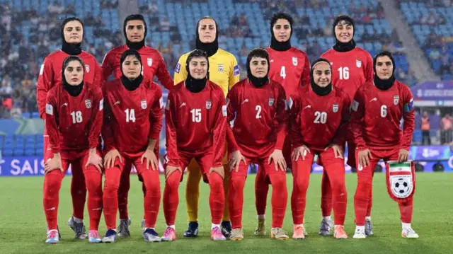The women's football team players lined up on the pitch